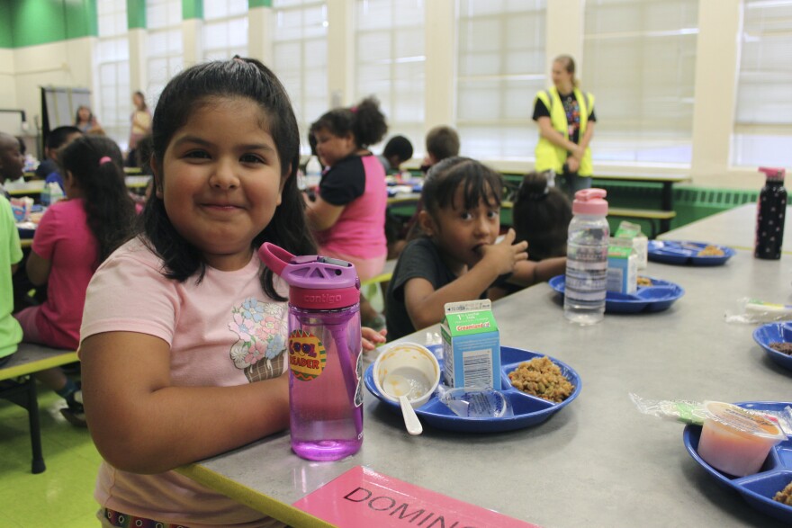 FILE - A student posing for a photograph after finishing lunch at Lowell Elementary School in Albuquerque, New Mexico, Aug. 22, 2023.