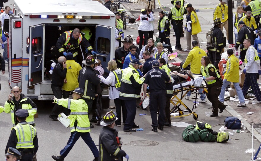 Amelia Nelson, next to the ambulance in the blue and white jacket, aids injured people at the finish line of the 2013 Boston Marathon on April 15, 2013.