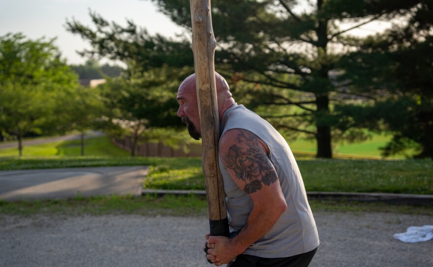 Man holds a caber in his hands.