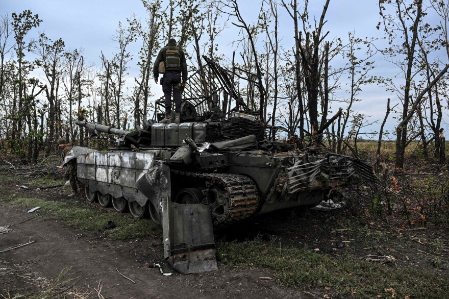 A Ukrainian soldier stands atop an abandoned Russian tank near a village on the outskirts of Izium, in the Kharkiv region, eastern Ukraine. Ukraine said its swift offensive took significant ground back from Russia.