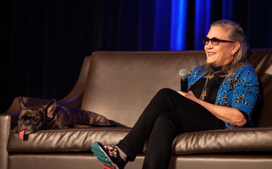 Carrie Fisher and her dog, Gary, take questions onstage at the Wizard World Chicago Comic-Con in August.