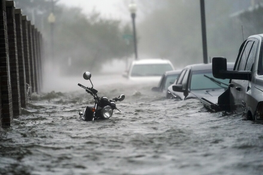 In this Sept. 16, 2020, file photo, flood waters move on the street, in Pensacola, Fla. Hurricane Sally made landfall near Gulf Shores, Alabama, as a Category 2 storm, pushing a surge of ocean water onto the coast and dumping torrential rain. This year has seen record Atlantic hurricanes and western wildfires, devastating floods in Asia and Africa and a hot, melting Arctic. It's not just been a disastrous year, but a year of disasters. (AP Photo/Gerald Herbert, File)