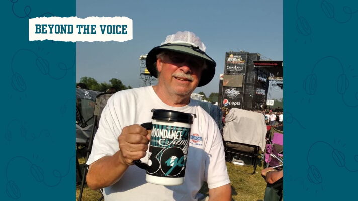 Man holds a mug at a music festival