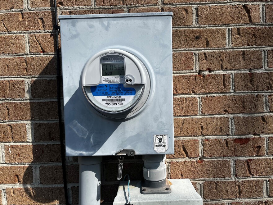 A grey metal box reading electricity usage on a home