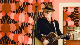 Tommy Stinson posing with a guitar.