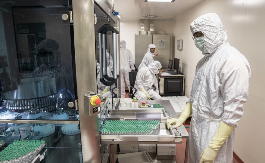 A technician at India's Serum Institute, the world's largest manufacturer of vaccines, waits to collect vials containing vaccine after they pass through a machine that checks for bottling and vaccine substance deficiencies. For a number of reasons, the supply of COVID vaccines for Indians has fallen short. So far only 4% of the population has been vaccinated.