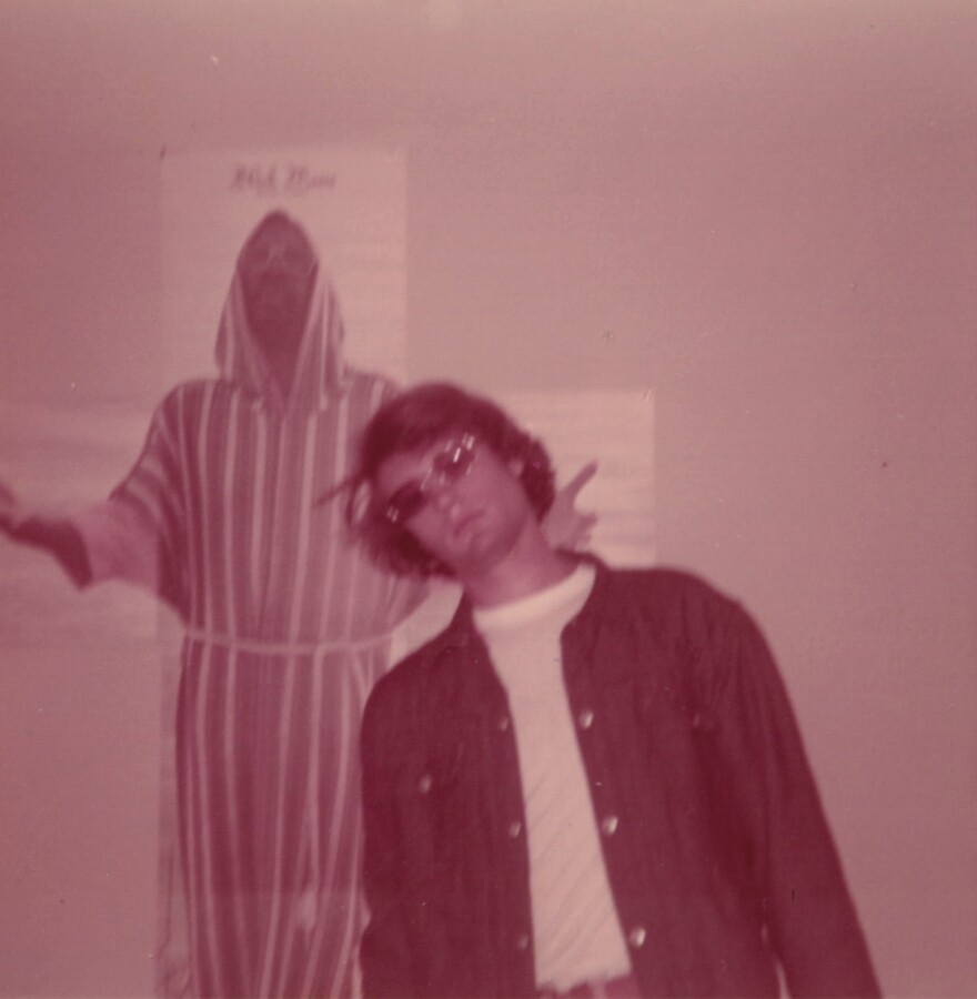 Faded early-1970s photo of a man with long hair and sunglasses posing in front of the fold-out poster from Isaac Hayes' album "Black Moses"