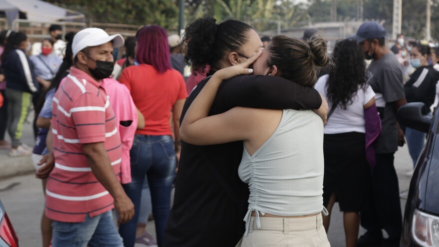 Women hug while waiting for some information about their relatives who are inmates at Litoral Penitentiary, after a prison riot, in Guayaquil, Ecuador, Wednesday. The authorities report at least 100 dead and 52 injured in the riot which began Tuesday at the prison.