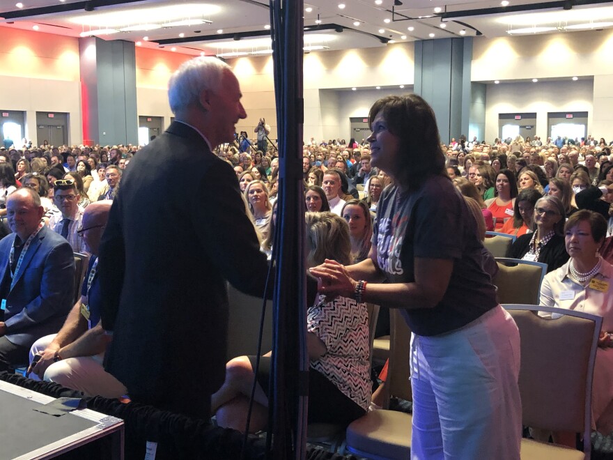 Gov. Asa Hutchinson greets a member of the Arkansas Association of Educational Administrators at the group's annual summer meeting at the Statehouse Convention Center in Little Rock Monday.