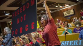 A Fenton resident cheers on a speaker who opposes the mask mandate as more than 100 people pack the Harris Auditorium as parents and county residents share opinions about the county's K-6 school mask mandate during public comment at a Genesee County Board of Commissioners meeting on Monday, Aug. 30, 2021, at the county administration building in downtown Flint, Mich.