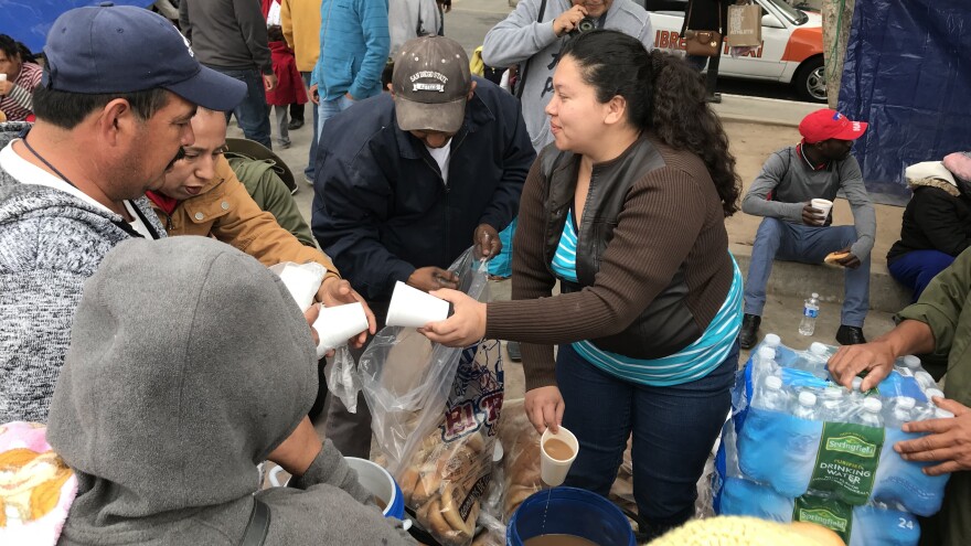 Volunteers pass out food and hot cocoa for migrants camped outside the U.S. port of entry in Tijuana.