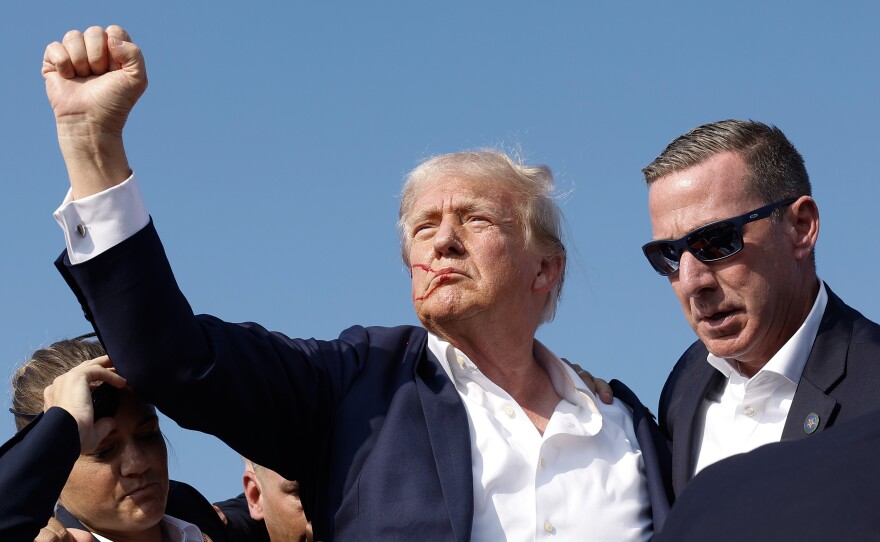 Republican presidential candidate former President Donald Trump pumps his fist as he is rushed offstage during a rally on July 13, 2024 in Butler, Pennsylvania.