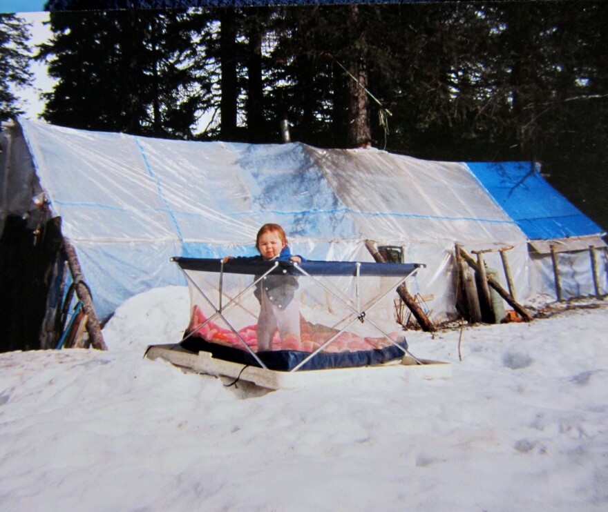 Detricia's daughter outside of their home: a plastic tent made of visqueen.