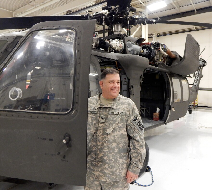 Col. David Caporicci, deputy commander of the 66th Theater Aviation Command, stands beside a UH-60 Blackhawk helicopter. After 28 years, budget cuts may threaten his job.