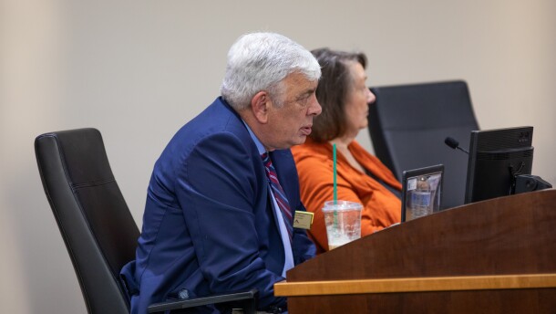 Board members David Perry, left, and Judy Justice, right, on dais in July 2025.