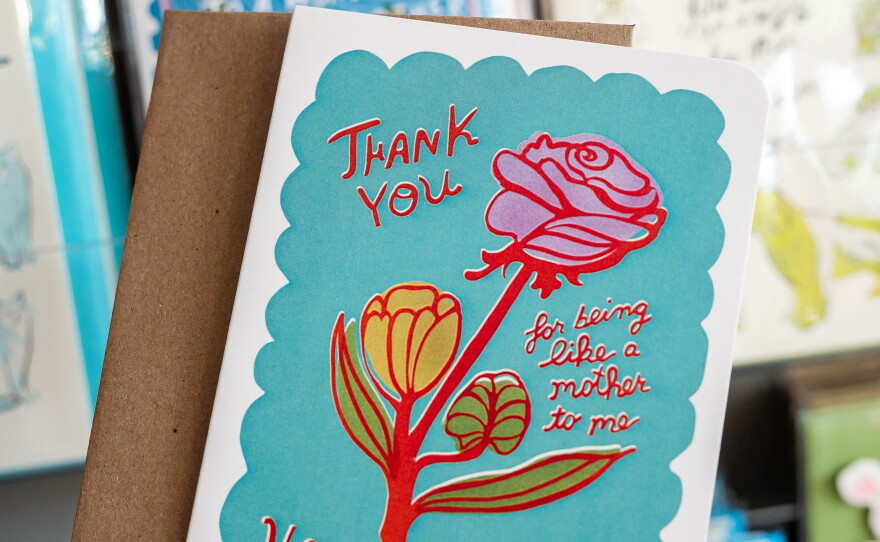 a hand holds a mothers day card that reads "Thank you for being like a mother to me. Happy Mothers Day"