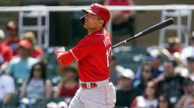joey votto, in a red baseball jersey and white baseball pants, mid swing