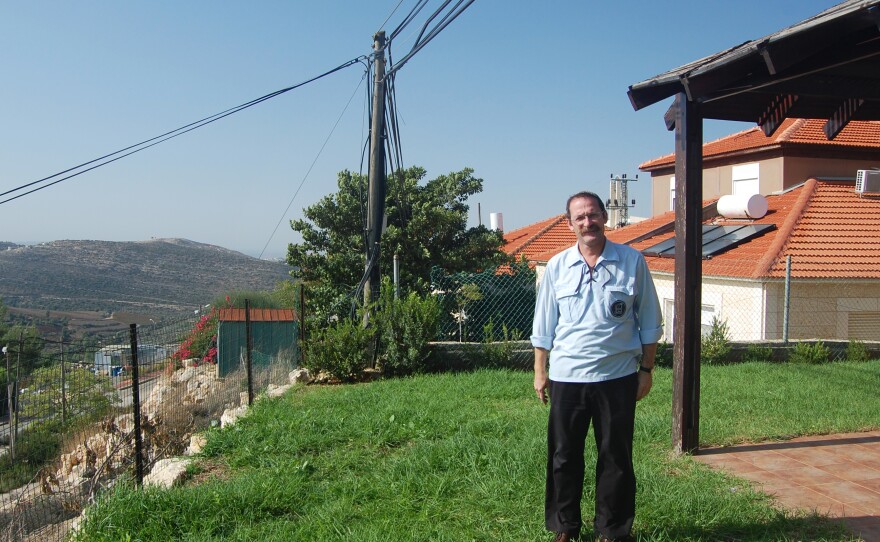 Danny Hirshberg, standing outside his home in a West Bank settlement, disagreed with Rabin's policies but helped organize this year's gathering in his memory.
