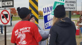 UAW Local 2209 members autograph each others picket signs while cleaning up on the last day of the nationwide strike.