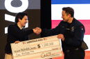 FILE - Elon Musk hands over a million dollar check to Nicholas Jacobs during a town hall in Green Bay, Wis., March 30, 2025.