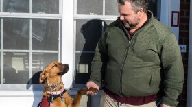 Army veteran Russel Keyser shakes hands with his dog, Artemis, outside of his Ronkonkoma, NY home. Keyser says the dog helps him deal with the effects of PTSD. (Paige Pfleger/American Homefront Project)