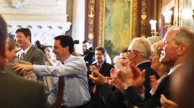 Wisconsin Gov. Scott Walker (center) is greeted by his Cabinet and staff Wednesday at the state Capitol in Madison, a day after defeating Milwaukee Mayor Tom Barrett in a recall election.