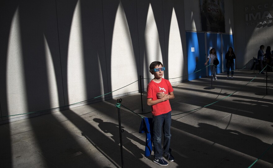 Rafaelle Del Pesce, 9, looks toward the sun during the solar eclipse on Monday, August 21, 2017, at the Pacific Science Center on 2nd Ave., in Seattle. 