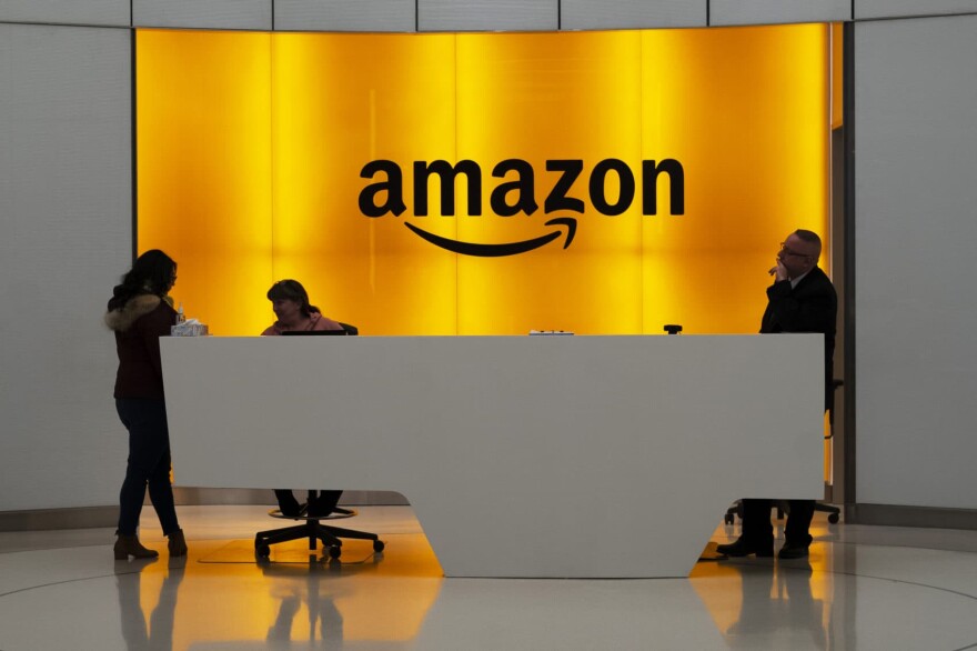 People stand in the lobby for Amazon offices Thursday, Feb. 14, 2019, in New York. Twenty-eight employees at Amazon have filed an activist shareholder proposal asking the company to take a stronger stance on climate change. (Mark Lennihan/AP)