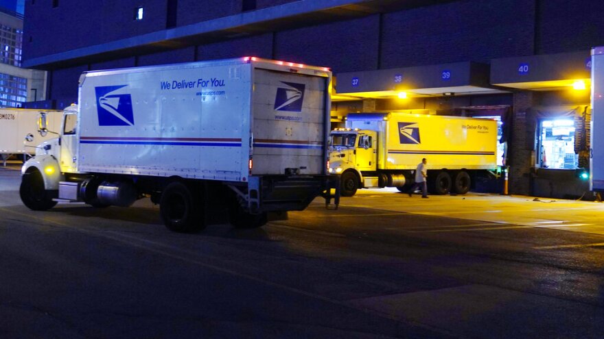 FILE - Delivery trucks arrive at the loading dock at the United States Postal Service sorting and processing facility Nov. 18, 2021, in Boston. The Environmental Protection Agency is raising concerns about a U.S. Postal Service plan to replace its huge fleet of mail-delivery trucks, saying the effort does not include enough electric vehicles. (AP Photo/Charles Krupa, File)