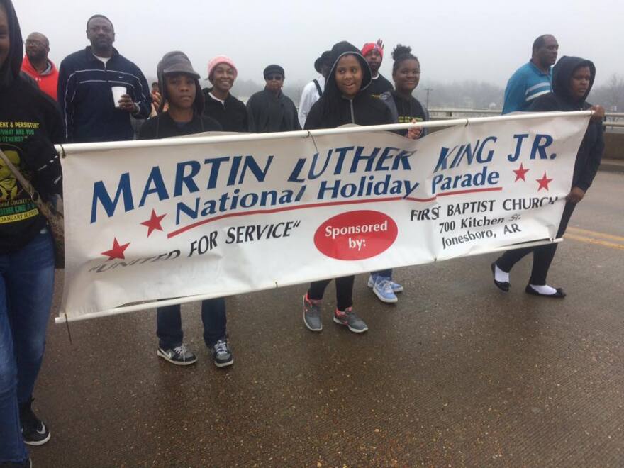 Participants of the 2017 Craighead County Dr. Martin Luther King Jr. Day parade walking across the Jonesboro Main St. bridge.