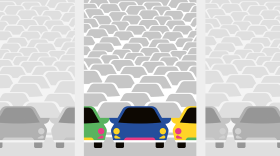Multi-colored cars sit on an empty car lot. 