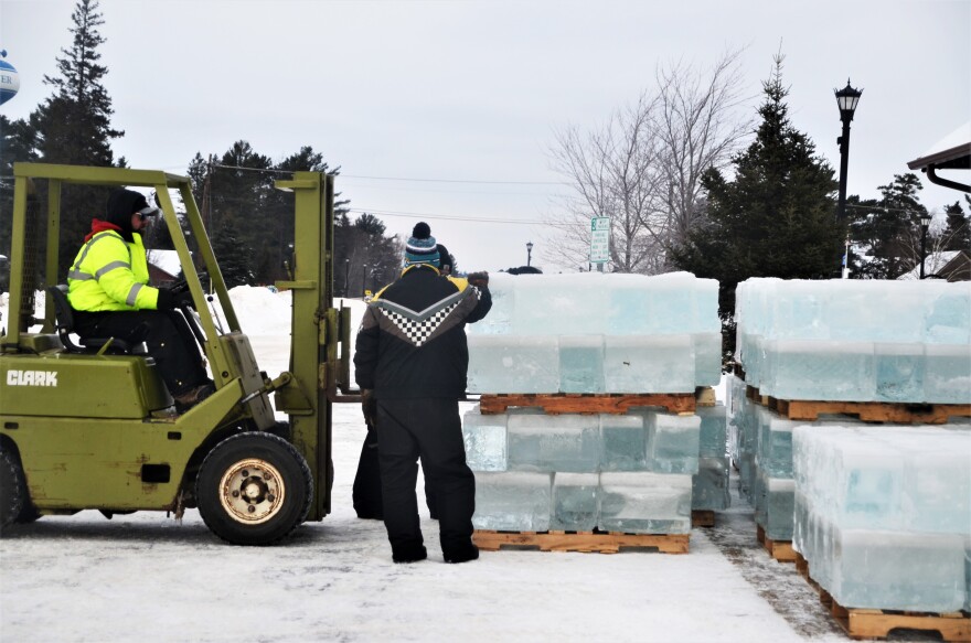 Volunteers stack pallet of ice on Saturday. Sunday they started shaving the blocks to uniform size and building the castle.