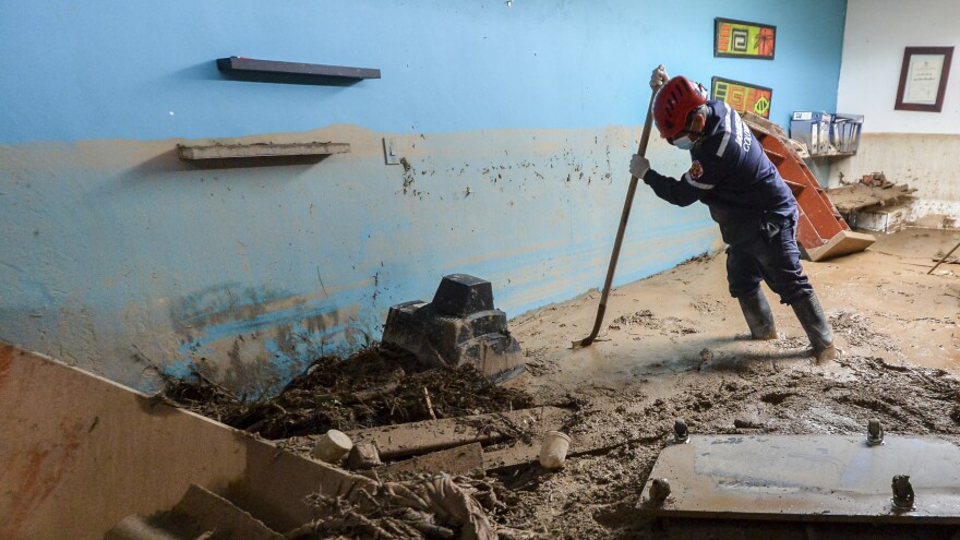 A fireman searches for victims inside a muddy house, following mudslides caused by heavy rains in Mocoa, Putumayo department, southern Colombia, on Sunday. Rescuers are clawing through piles of muck and debris in search of survivors.