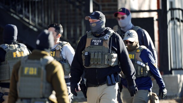 Law officials spread out through an apartment complex during a raid Wednesday, Feb. 5, 2025, in east Denver.