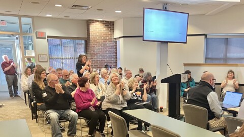 Audience members at a Pekin City Council meeting cheer an announcement by Mayor Mary Burress that the city is no longer interested in having a data center built in the community.