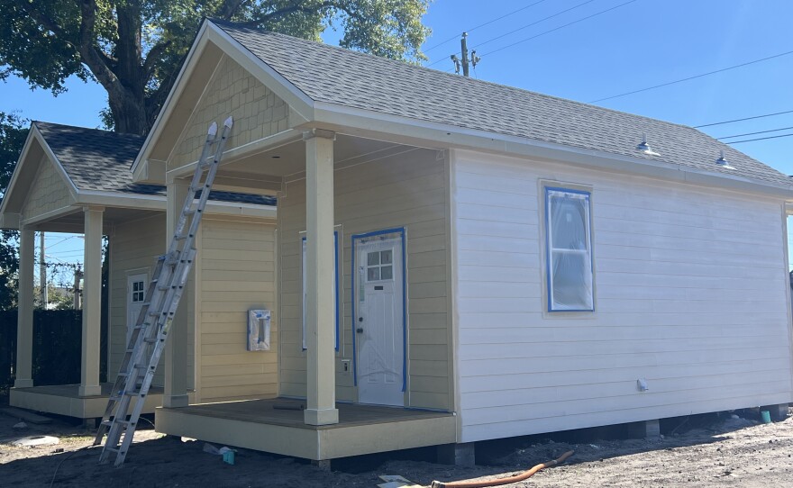 Workers put the finishing touches on pastel-colored cottages at Trinity Village, a new tiny home community in downtown Pensacola built by the Catholic Diocese of Pensacola-Tallahassee for low-income seniors.