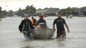 The Tellez family is evacuated from their home after severe flooding following Hurricane Harvey in north Houston Aug. 29, 2017. (Win McNamee/Getty Images)