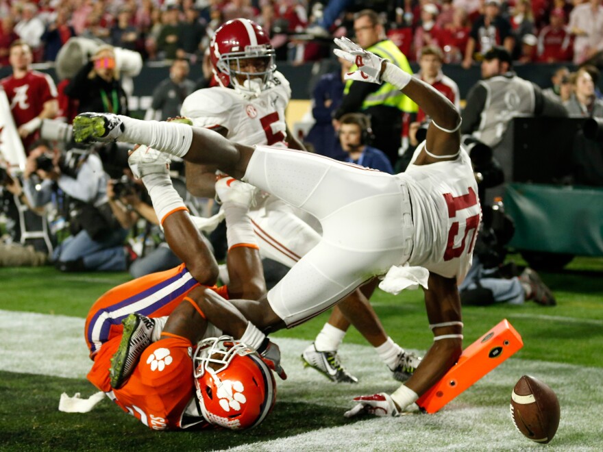 Wide receiver Artavis Scott of the Clemson Tigers loses the ball in the end zone as he's bowled over by Ronnie Harrison of the Alabama Crimson Tide in the third quarter.