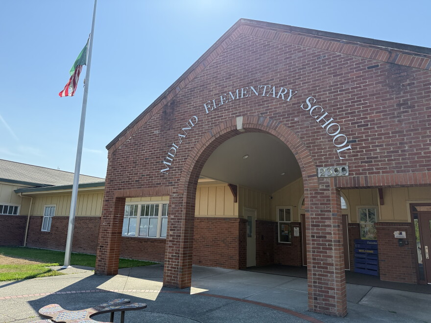 A brick archway in front of a school reads: Midland Elementary
