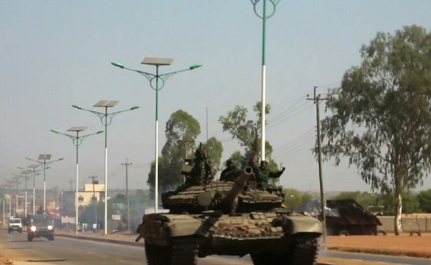 A military tank patrols along one of the main roads in the South Sudanese capital of Juba on Dec. 16, 2013, when a citywide curfew was declared.