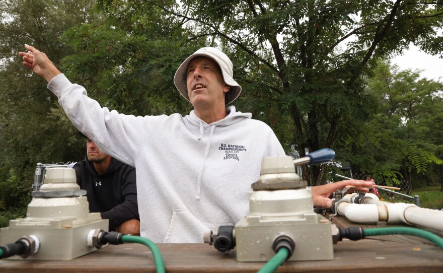 Bristol Mountain Freestyle Coach, Johnny Kroetz, signals a skier to jump while turning on the air bubbles in the pond to cousion the landing at the Bristol Mountain water ramp.