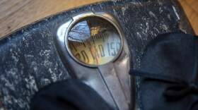 A person stands on an old body weight scale. (Robin Lubbock/WBUR)