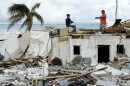 Workers talk atop a building that was heavily damaged by Hurricane Ian at Fort Myers Beach, Fla., on Oct. 9, 2022