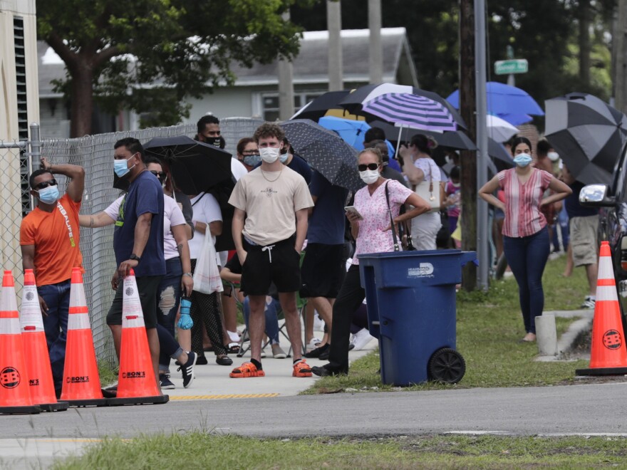 People wait in line outside of a COVID-19 testing site in Florida. The state has seen unprecedented surges in coronavirus cases in recent weeks.