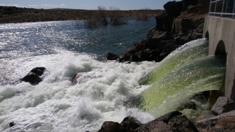 Water rushes through a tunnel into a man-made lake in the Magic Valley desert.  