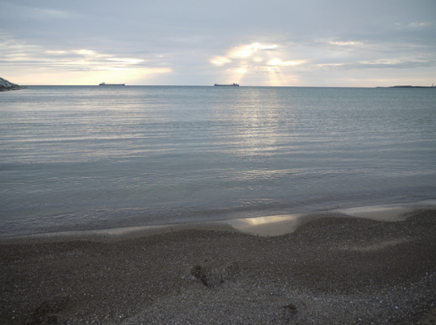 A sandy beach on a partly cloudy day. 