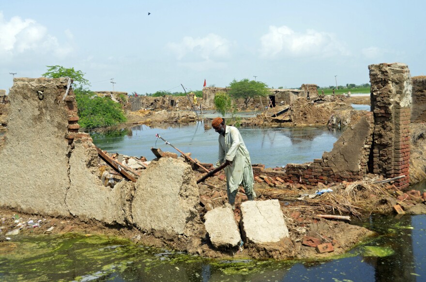 A man looks for salvageable belongings from his flood-hit home in Jaffarabad, a district of Pakistan's southwestern Baluchistan province, on Sunday.