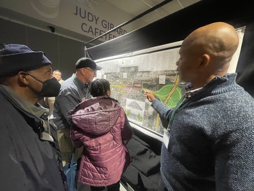 Local business owner Joe Conyers reviewing proposed plans for the extension of Independence Blvd. with NCDOT employee Jamille Robbins. Many businesses that fall along the path of the extension, like Conyers', would have to be relocated.