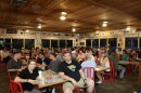 Large crowds sit at a restaurant dining hall, waiting to hear from a governor candidate.