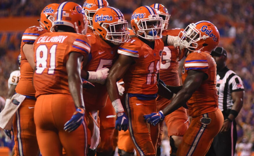 As fireworks erupt overhead, Florida wide receiver Demarcus Robinson (11) celebrates with him teammates after scoring a touchdown in the third quarter.